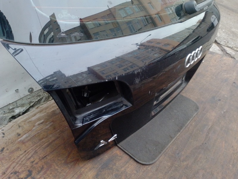 Дверь задняя крышка багажника на Audi A4 B7 / Ауди А4 Б7 2004-2009г.\nОригинал.\nПрисутствуют потертости и царапины.\nЗаводская краска. Цвет черный. Без жучков и коррозии.\nВ сборе целиком вся дверь как на фото: стекло, эмблемы, обшивка, замок двери.\nКон