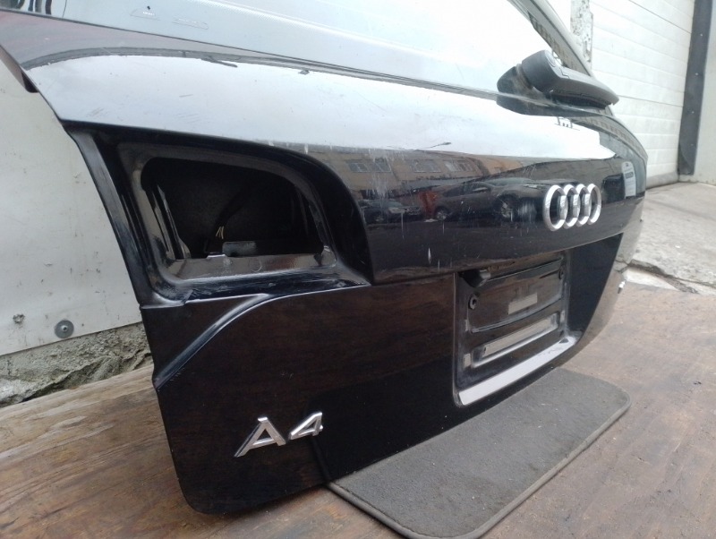 Дверь задняя крышка багажника на Audi A4 B7 / Ауди А4 Б7 2004-2009г.\nОригинал.\nПрисутствуют потертости и царапины.\nЗаводская краска. Цвет черный. Без жучков и коррозии.\nВ сборе целиком вся дверь как на фото: стекло, эмблемы, обшивка, замок двери.\nКон